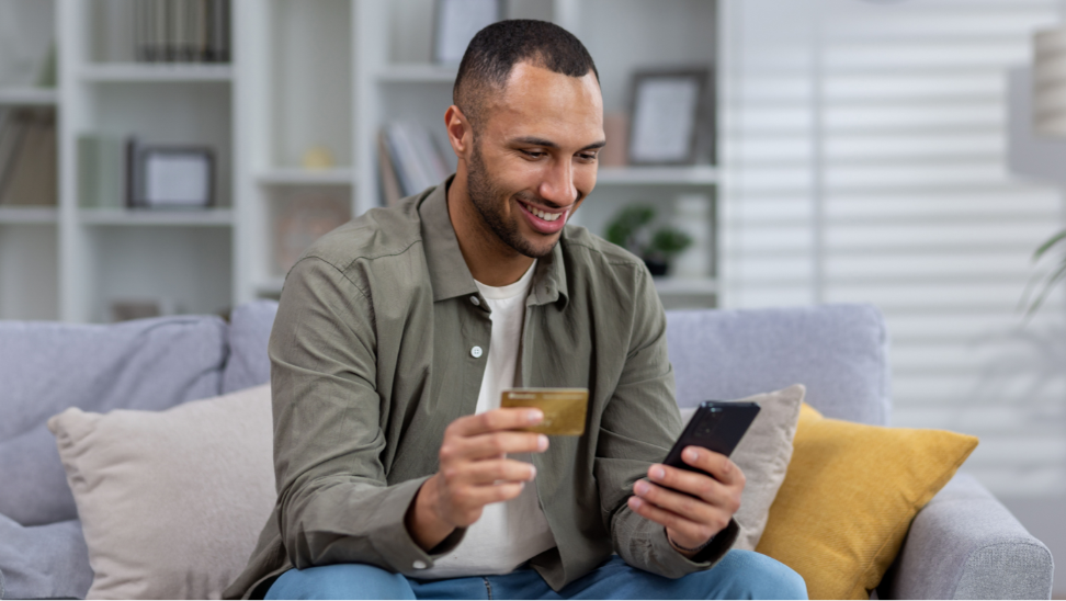 Man looking at phone with credit card